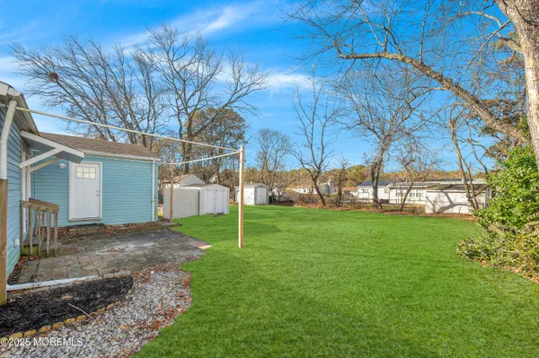 a view of a house with backyard and a tree