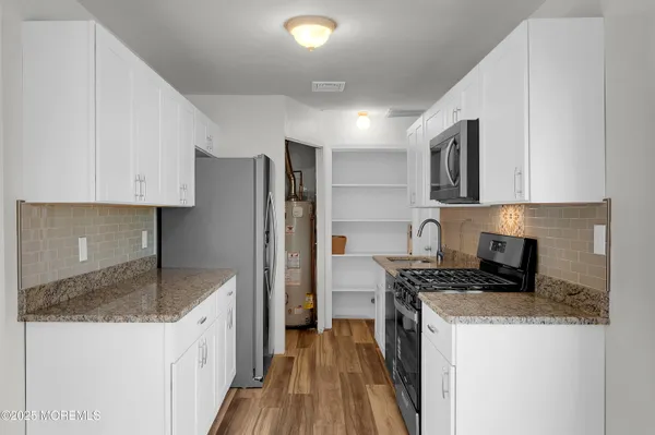 a kitchen with granite countertop a sink stove and refrigerator