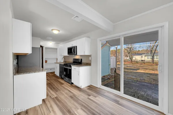 a view of a kitchen with sink refrigerator and wooden floor