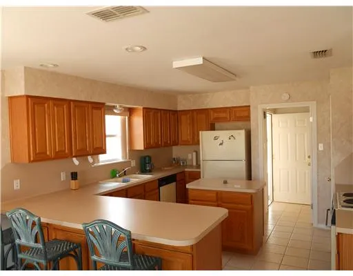 a living room with stainless steel appliances granite countertop a couch a rug and a window