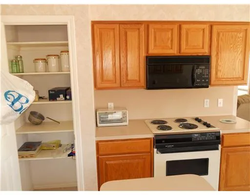 a kitchen with granite countertop cabinets stove top oven and microwave