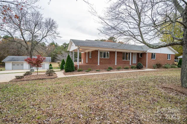 a front view of a house with a yard and trees
