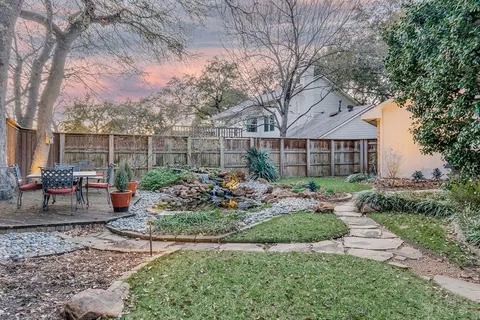 a garden with flowers and wooden fence
