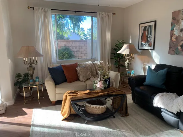 a living room with furniture a table and wooden floor
