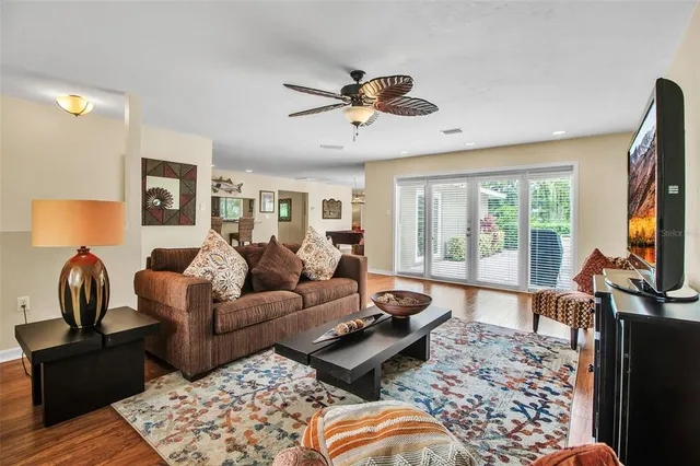 a living room with furniture ceiling fan and a window