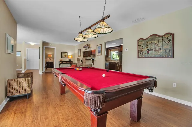 a room with pool table and windows