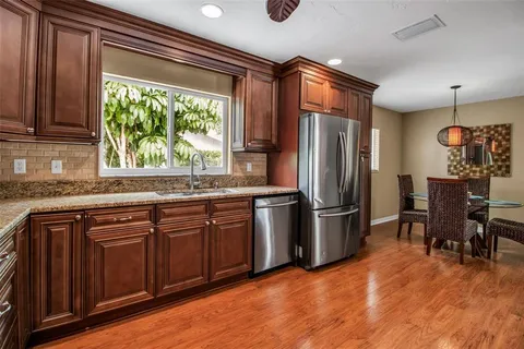 a kitchen with stainless steel appliances granite countertop a refrigerator and a sink