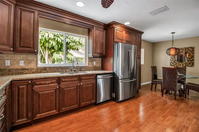 a kitchen with stainless steel appliances granite countertop a refrigerator and a sink