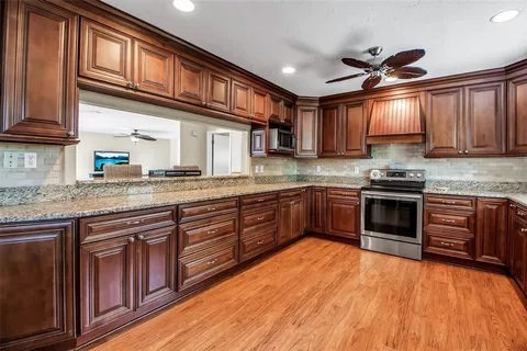 a kitchen with stainless steel appliances granite countertop a stove sink and cabinets