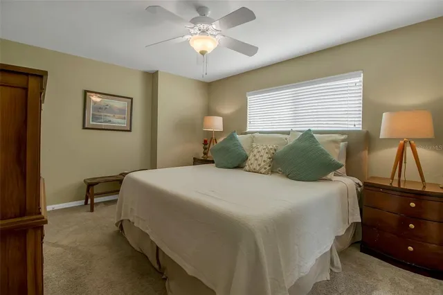 a bedroom with a bed and a lamp on dresser