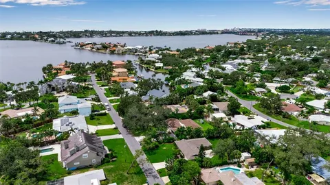 an aerial view of a city with lots of residential buildings ocean and mountain view in back