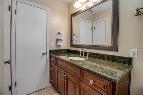a bathroom with a granite countertop sink and a mirror
