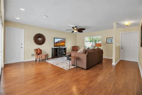 a living room with furniture and a wooden floor