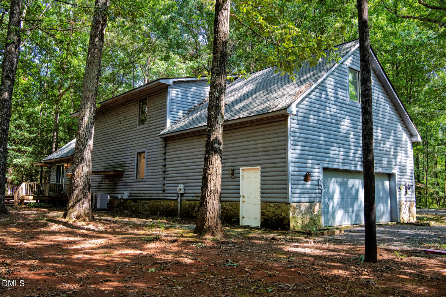 7391 Howerton Road Elon, NC 27244 - Photo 45 of 53 Exterior featuring log cabin siding, stone foundation, multi-pane windows, and an attached two-car garage