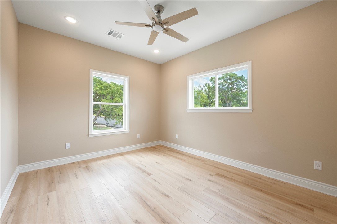 3213 Link Street, Unit 116 Bryan, TX 77801 - Photo 12 of 27 an empty room with wooden floor ceiling fan and windows