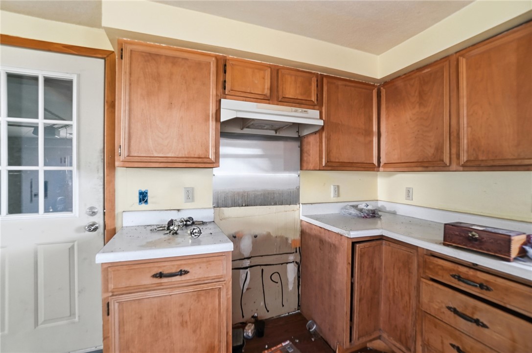9750 Middlepoint Road Middle Point, OH 45863 - Photo 15 of 43 This kitchen presents a practical layout, featuring wooden cabinetry and ample counter space.