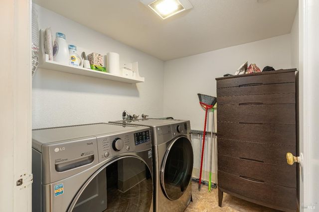 a view of washer and dryer with wooden cabinets