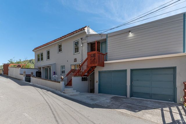 a view of a house with a barbeque and wooden stairs