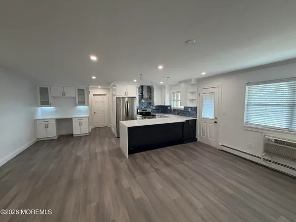 a large kitchen with stainless steel appliances granite countertop a large counter top a sink and a stove