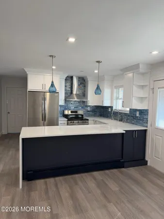 a view of kitchen with granite countertop stainless steel appliances a sink and refrigerator