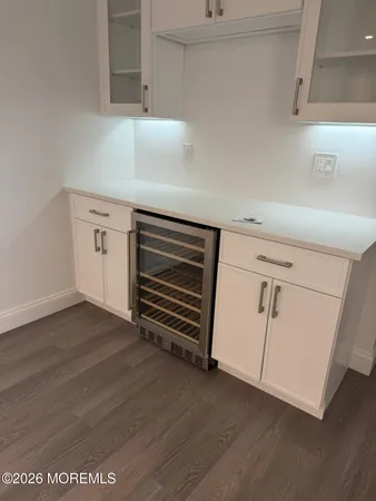 a view of an empty room with wooden floor and cabinets