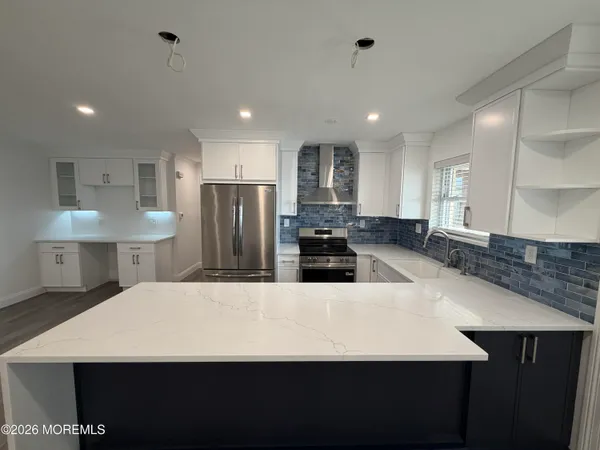 a large kitchen with stainless steel appliances a large counter top