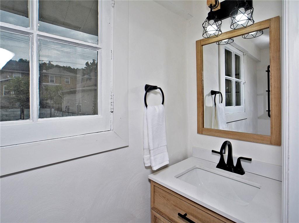 1423 Chislett Street Pittsburgh, PA 15206 - Photo 14 of 47 a bathroom with a sink a mirror and shower