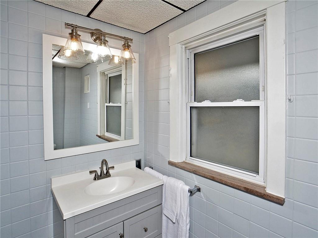 1423 Chislett Street Pittsburgh, PA 15206 - Photo 19 of 47 a bathroom with a sink and mirror with toilet