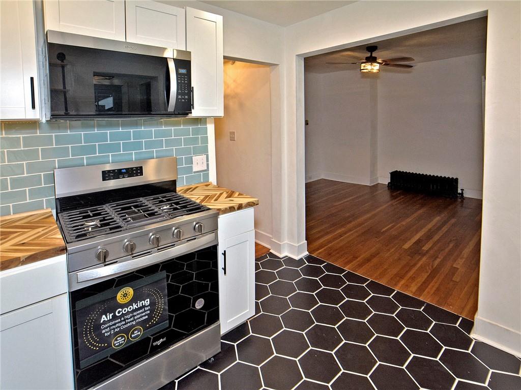 1423 Chislett Street Pittsburgh, PA 15206 - Photo 43 of 47 a kitchen with granite countertop a stove top oven a sink and a microwave