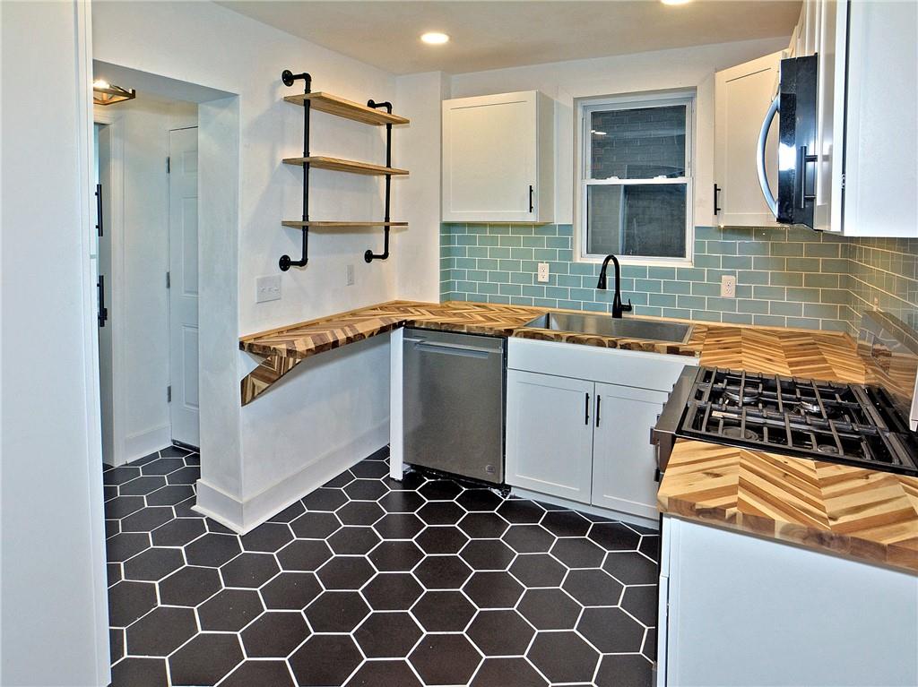 1423 Chislett Street Pittsburgh, PA 15206 - Photo 7 of 47 a kitchen with a sink a stove and refrigerator