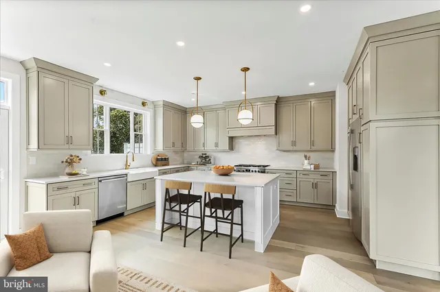 a kitchen with a refrigerator a stove a sink dishwasher with a dining table and chairs