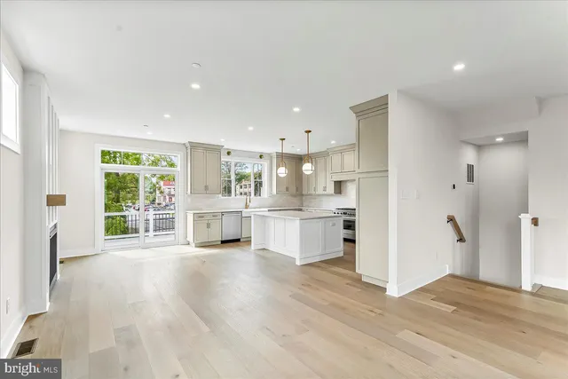 a room with white cabinets and wooden floor