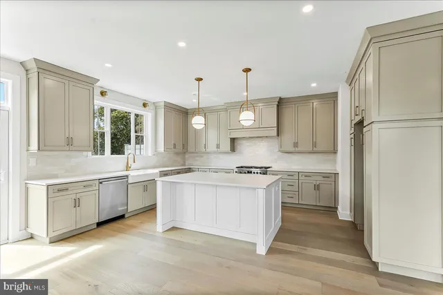 a large kitchen with stainless steel appliances granite countertop a stove and a refrigerator