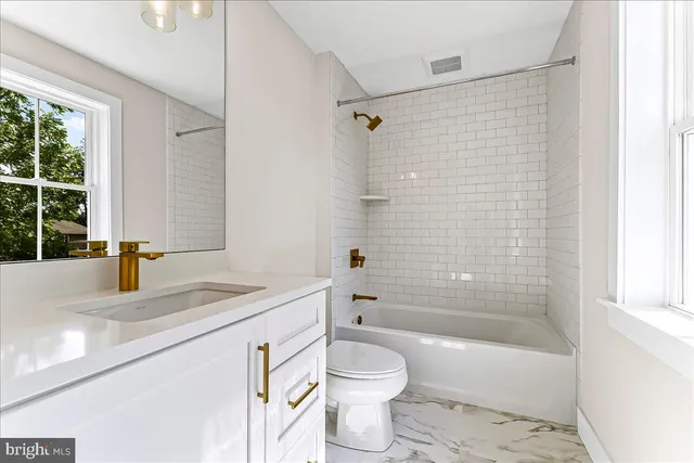 a bathroom with a sink mirror and toilet