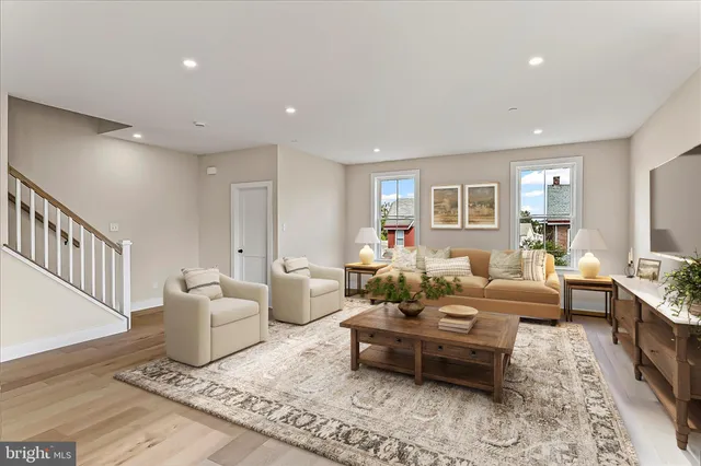 a living room with furniture wooden floor and a window