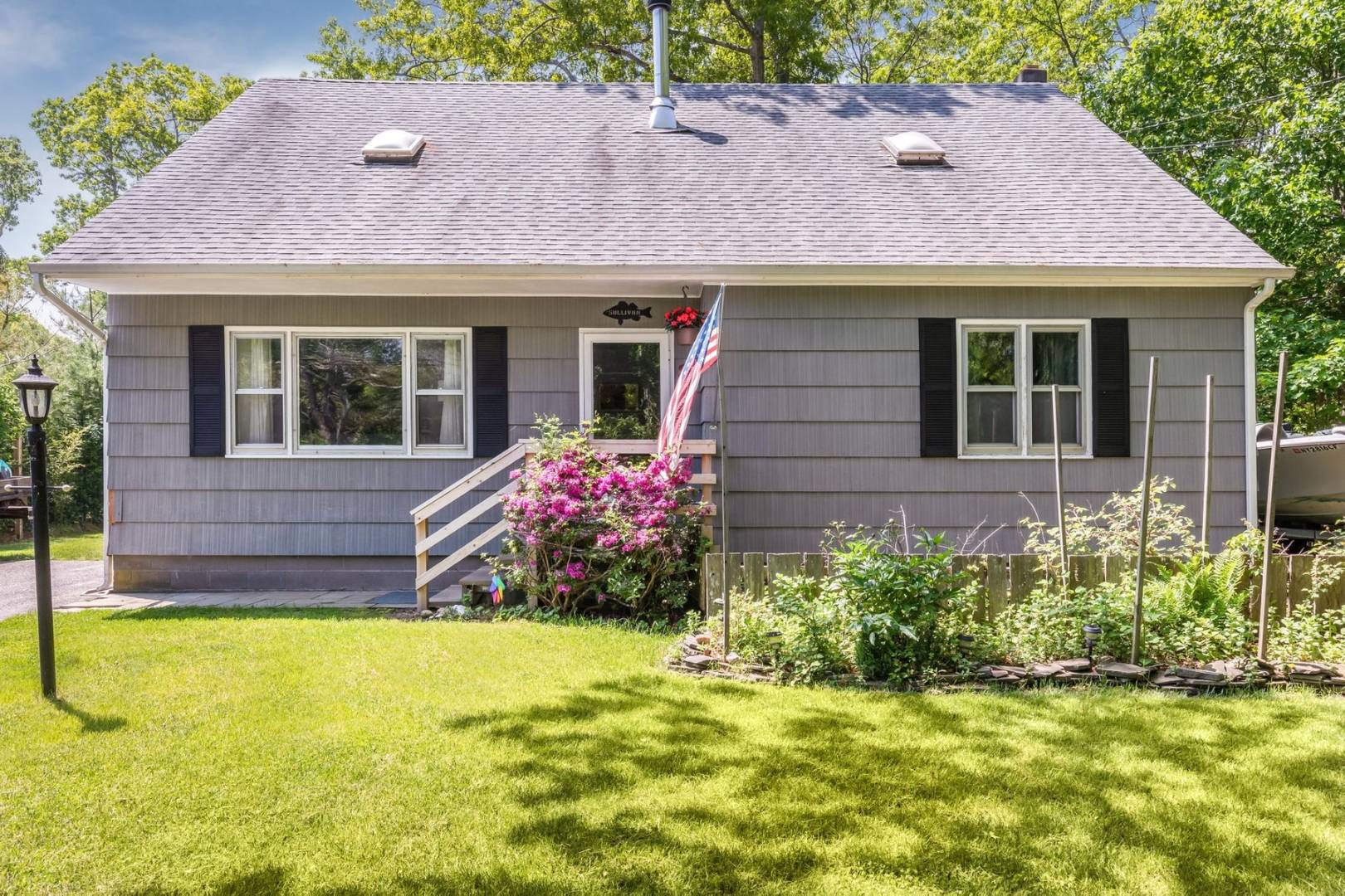 8 Bruce Lane East Hampton, NY 11937 - Photo 8 of 13 a front view of a house with a garden and yard