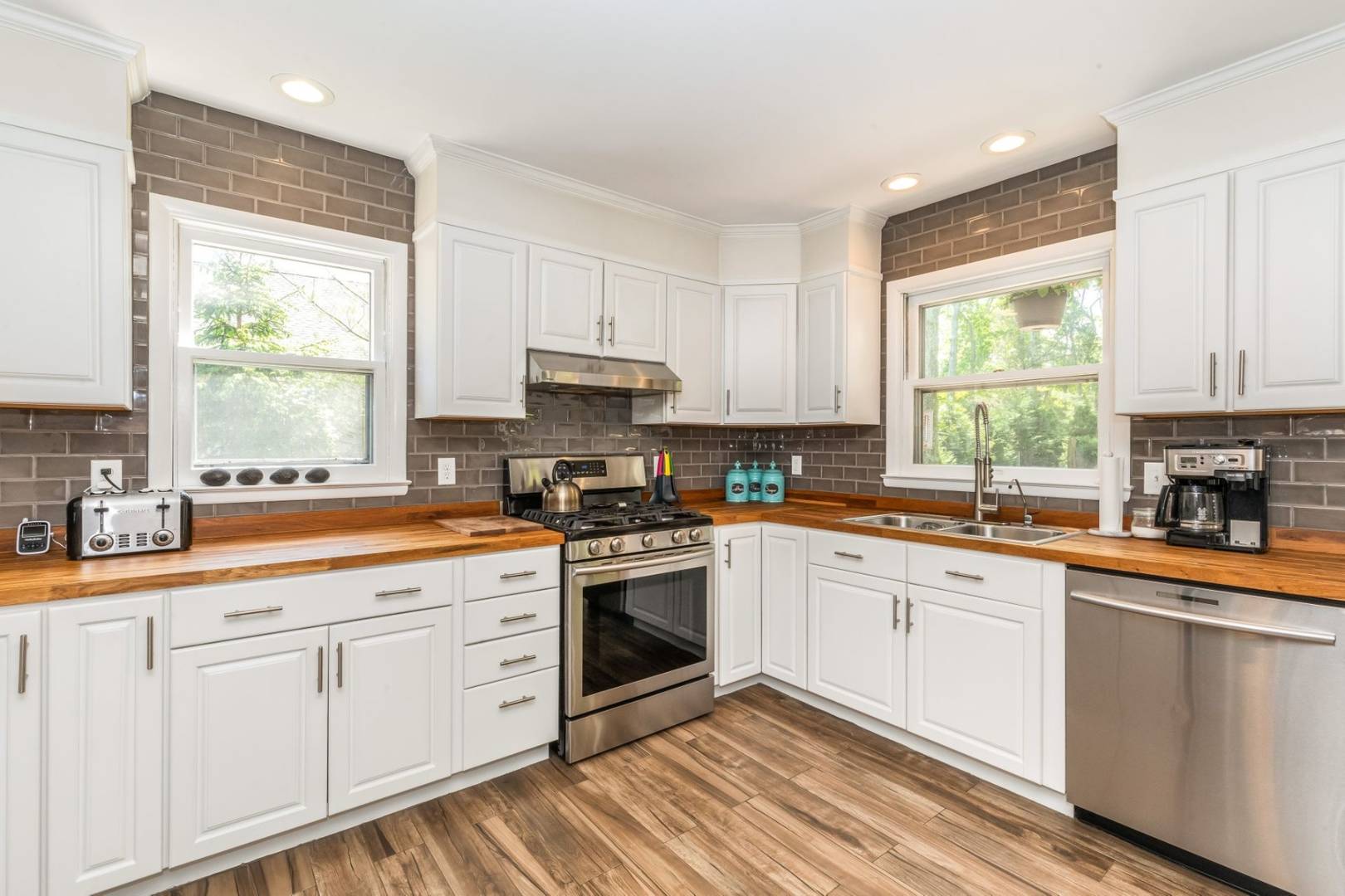 8 Bruce Lane East Hampton, NY 11937 - Photo 10 of 13 a kitchen with white cabinets appliances a sink and a window