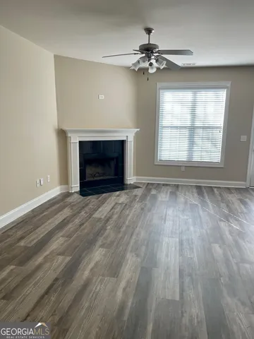 wooden floor fireplace and windows in an empty room