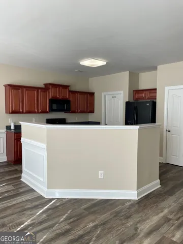 a living room with stainless steel appliances kitchen island a large counter top and a living room view
