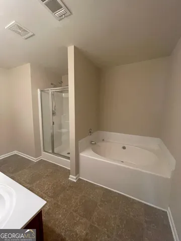 a spacious bathroom with a bathtub and a sink