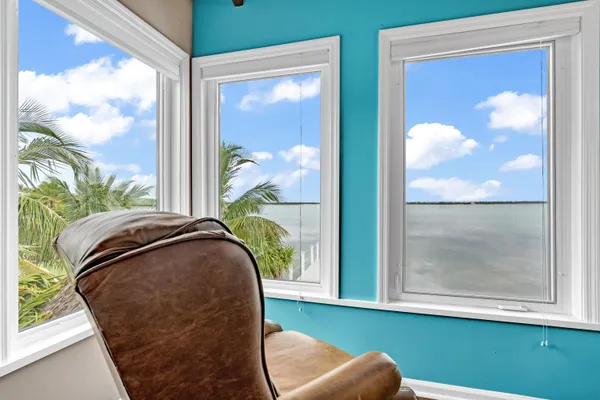 a view of a bedroom with wooden floor and windows