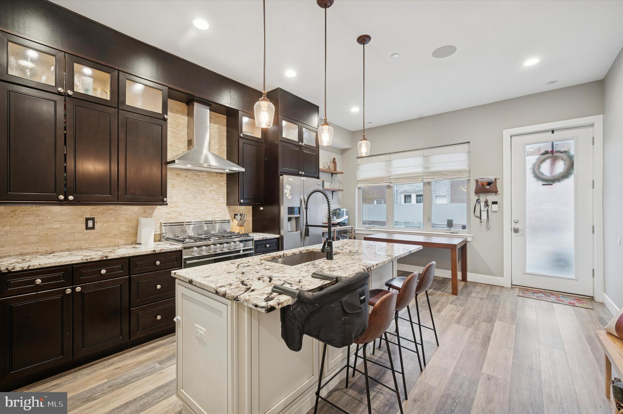 1942 Tasker Street Philadelphia, PA 19145 - Photo 2 of 35 a kitchen with stainless steel appliances granite countertop a sink a stove and a wooden floors