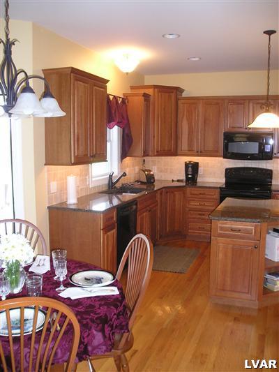 144 Heyer Road Nazareth, PA 18064 - Photo 3 of 31 a kitchen with granite countertop a stove a sink dishwasher and cabinets with wooden floor