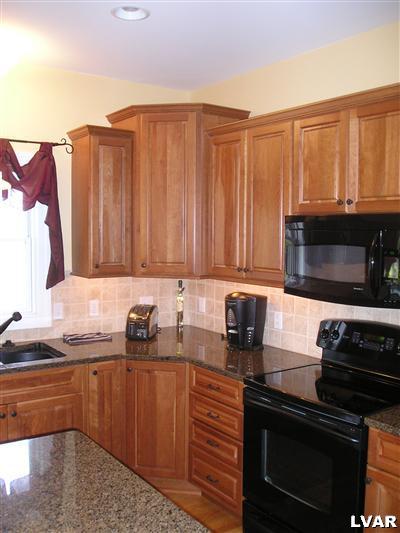 144 Heyer Road Nazareth, PA 18064 - Photo 4 of 31 a kitchen with stainless steel appliances granite countertop a stove a sink and a microwave