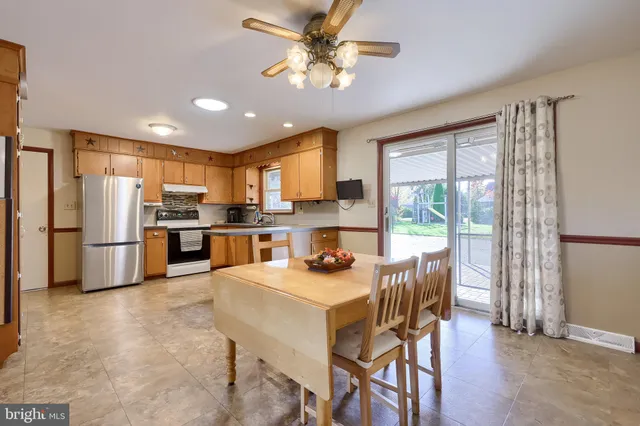 a kitchen with stainless steel appliances granite countertop a refrigerator a sink dishwasher a stove and white cabinets