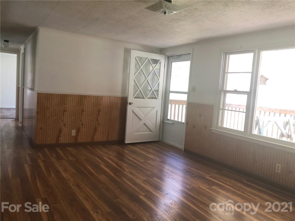 289 Long Branch Road Clyde, NC 28721 - Photo 11 of 44 an empty room with wooden floor and windows