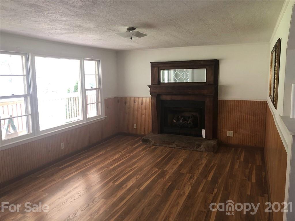289 Long Branch Road Clyde, NC 28721 - Photo 20 of 44 a view of an empty room with a fireplace and a window