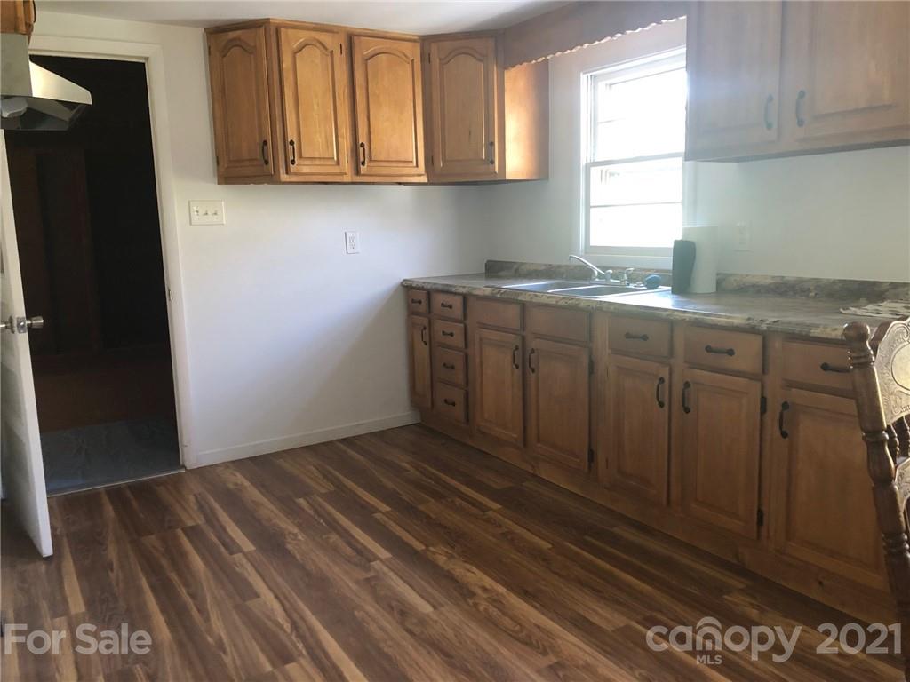 289 Long Branch Road Clyde, NC 28721 - Photo 6 of 44 a kitchen with granite countertop white cabinets and window