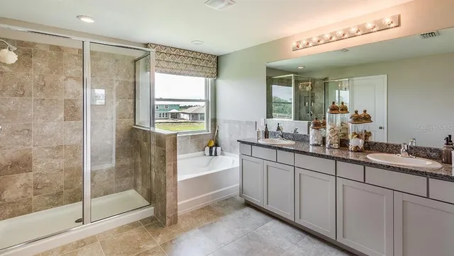 a spacious bathroom with a shower sink and mirror