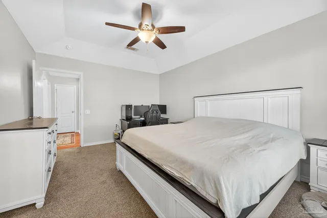 a bedroom with a bed and a ceiling fan